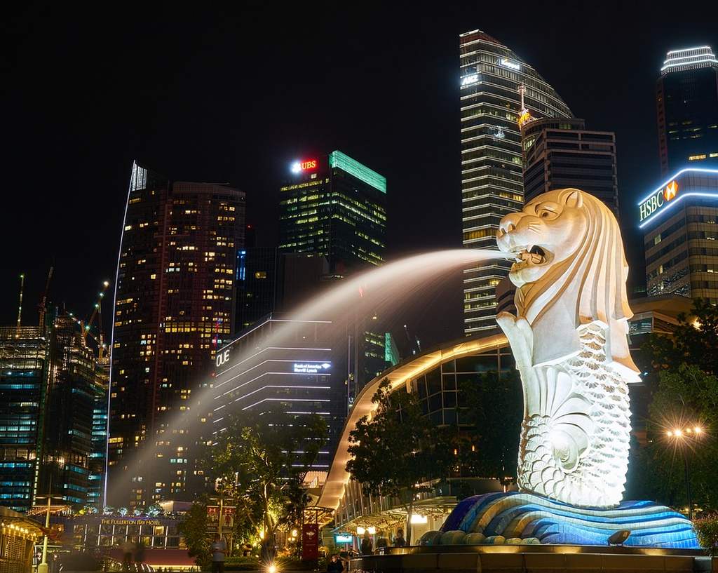 Der Merlion vor der Silhouette Singapurs bei Nacht